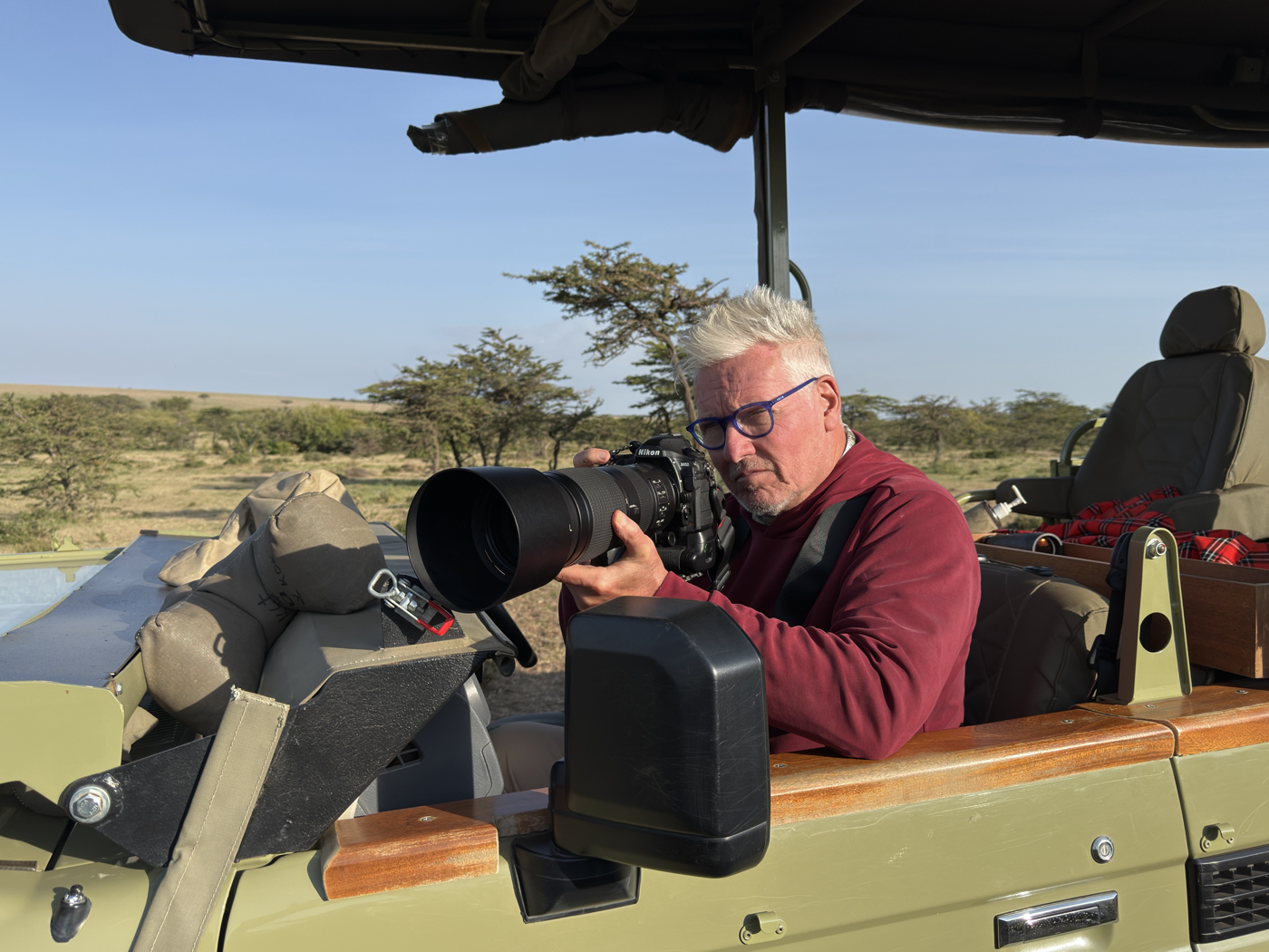 Harry Martin photographing wildlife from a safari vehicle in Kenya
